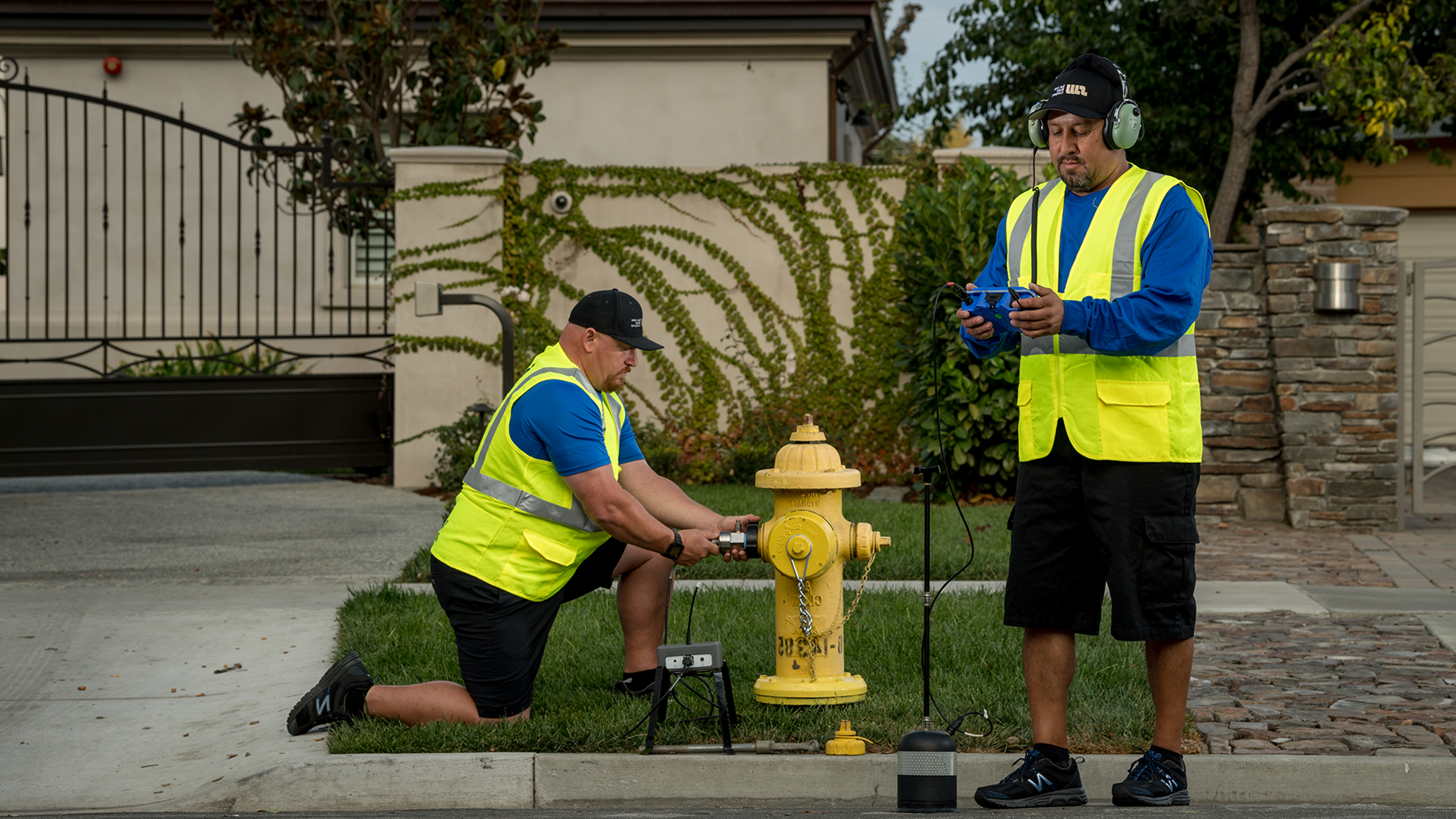 两名DG真人游戏务公司的男性员工正在检查一个住宅消防栓